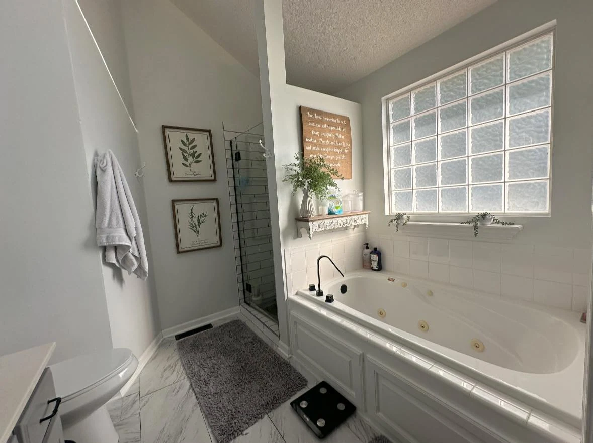 Bathroom with a bathtub and tall window