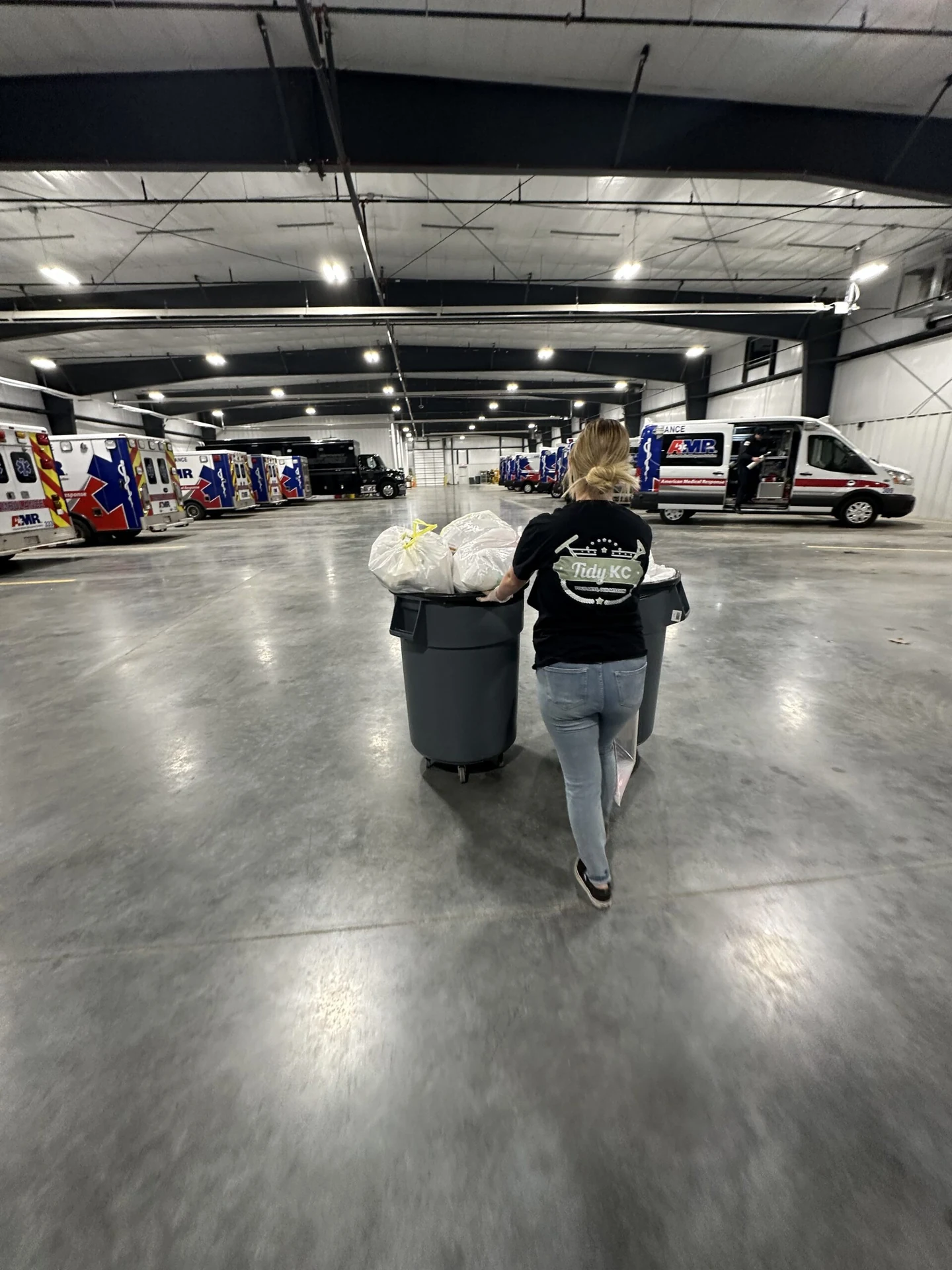 Tidy KC team member collecting trash in a commercial vehicle bay